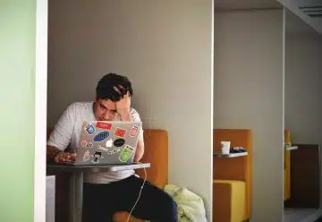 man wearing white top using MacBook